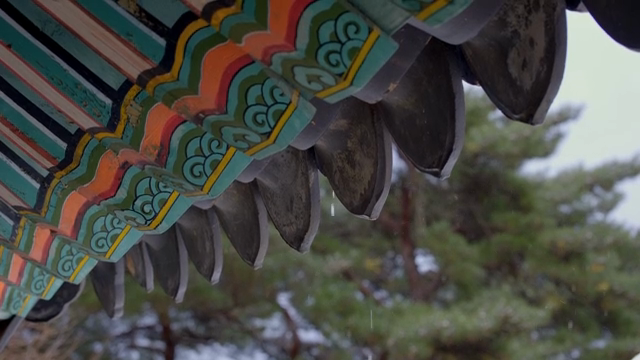 Traditional Korean roof with snow falling