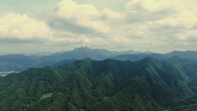 Lush green mountains under a cloudy sky