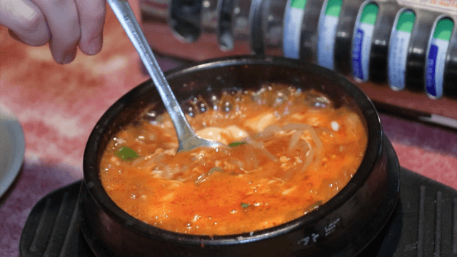 숟가락으로 젓는 뚝배기에 담긴 순두부찌개
