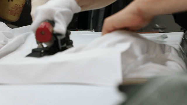 Person ironing white fabric with care