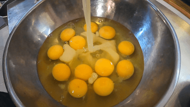 Thick soy liquid poured into eggs in steel bowl