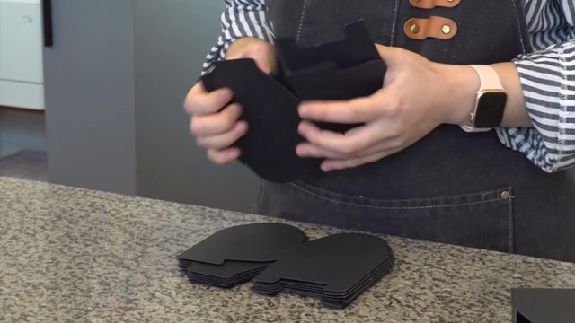 Person assembling black paper boxes