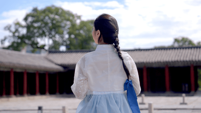 역사적인 장소에 선 전통 한복 입은 여성