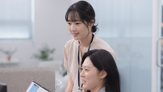 Two colleagues discussing work at a desk