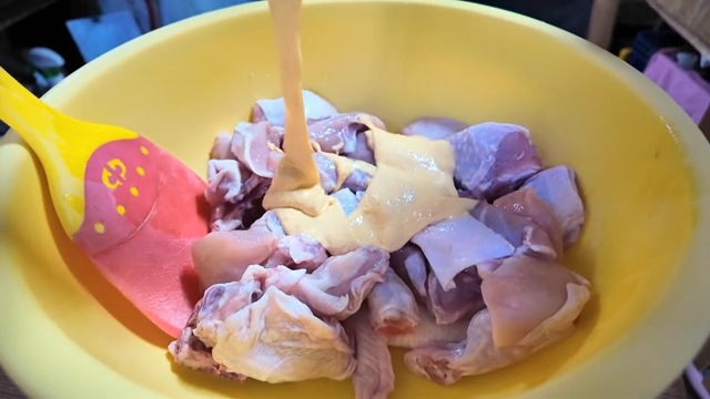 Mixing the batter into the raw chicken pieces