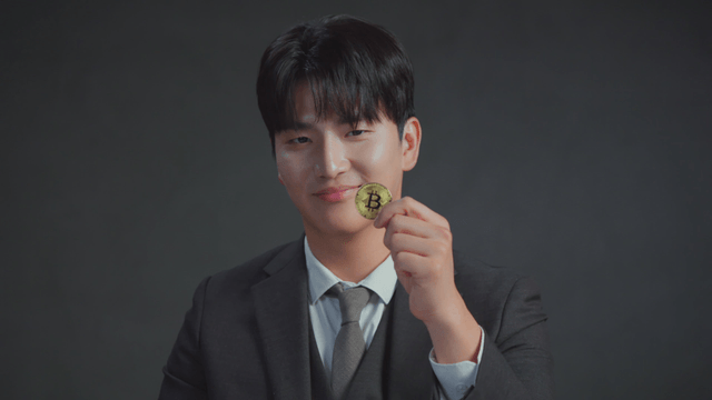 Smiling man holding a Bitcoin