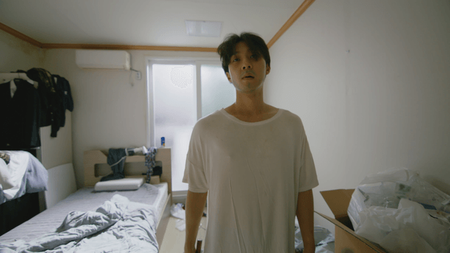 Man holding a hammer in a messy room