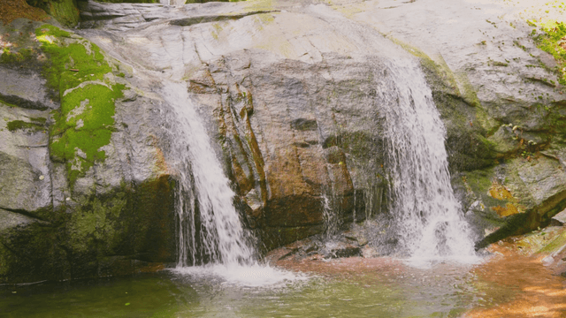 Small waterfall falling over large rock