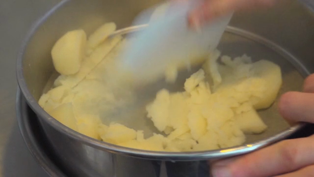 Potatoes being mashed in a kitchen