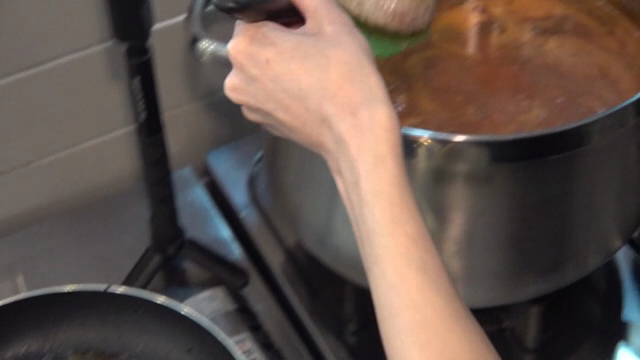 Patties placed in simmering sauce in a pot