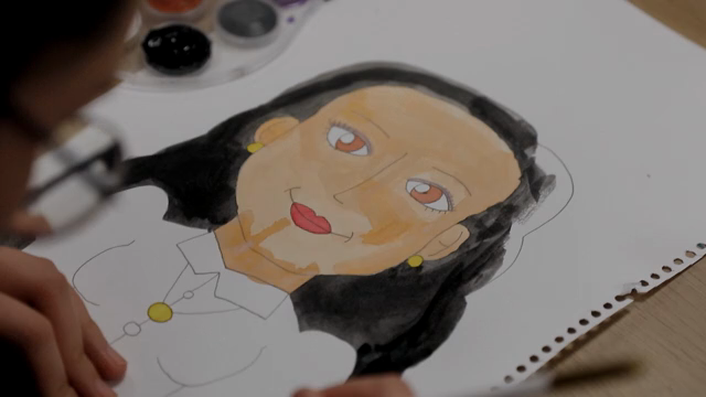 A person painting a portrait on paper