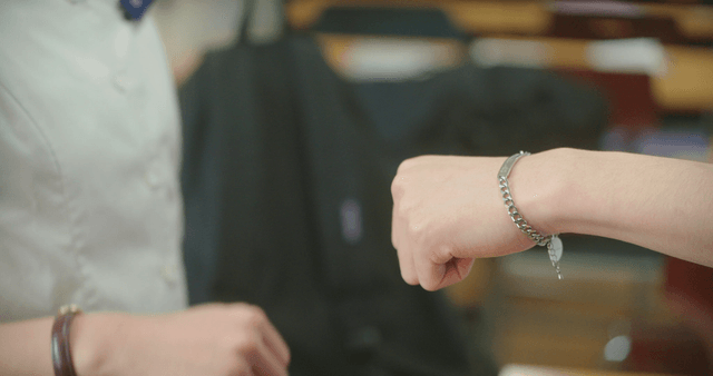 Two student fist bumping in a classroom