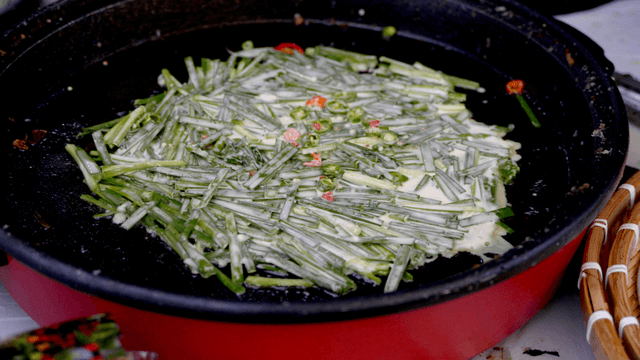 Chive pancake cooking in a skillet