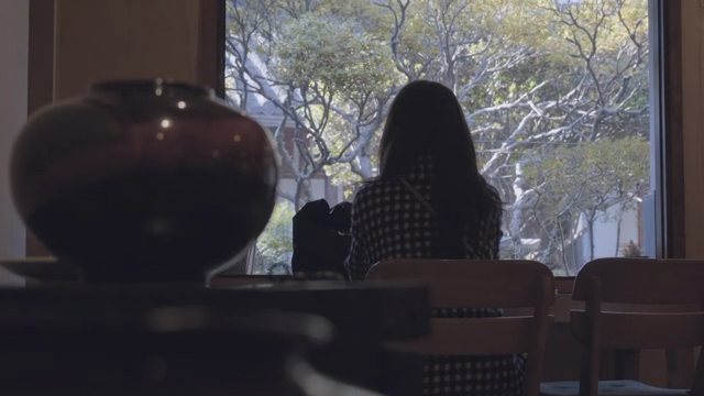 A woman sitting by a window with a view
