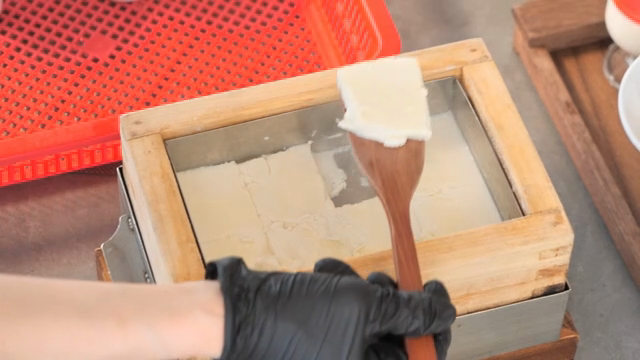 A person preparing tofu in a steamer