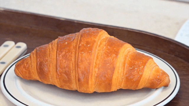 흰 접시에 놓인 크루아상