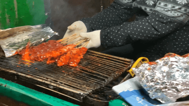 길거리에서 매운 닭꼬치를 굽는 상인