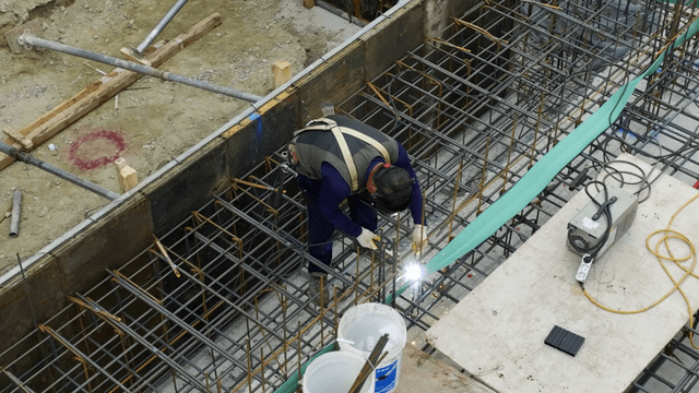 Construction worker welding rebar