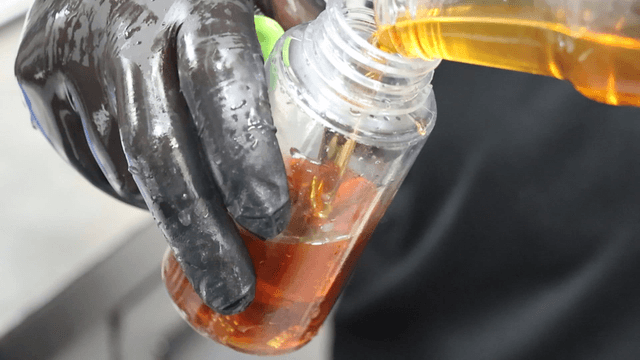 Sesame oil being precisely poured into a bottle