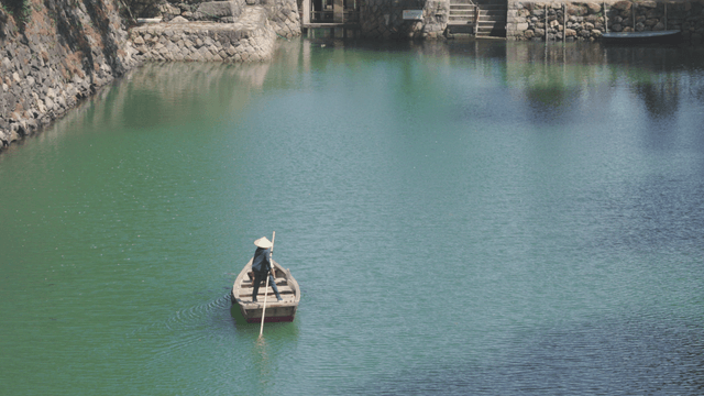 Person rowing a boat on a calm river