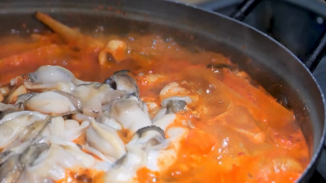 Spicy razor clam jjigae boiling in a pot
