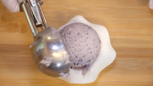 Ice cream being scooped onto a mochi base