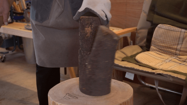 Woodcraft artisan examining wood in a cozy workshop