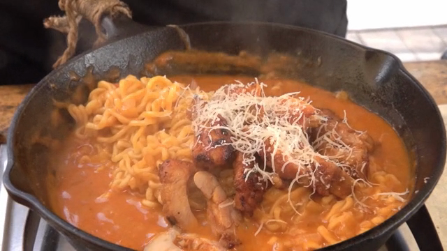 Cheese sprinkled on ramyeon with spicy stir-fried chicken