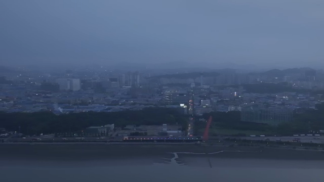 A city skyline with a river at dusk