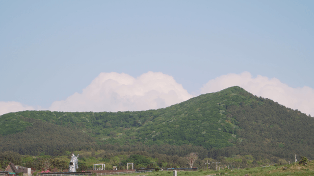 Green mountain under a clear blue sky