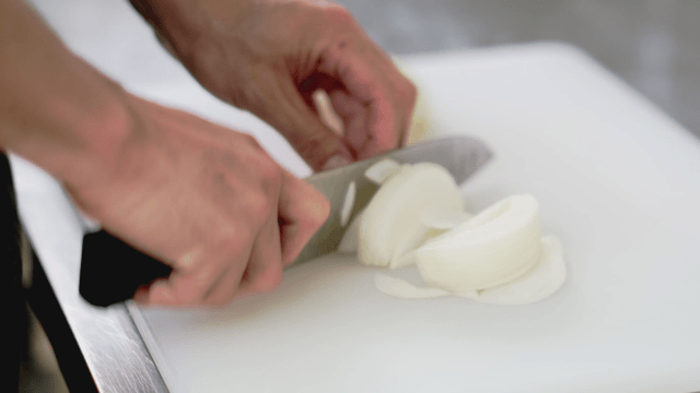 Slicing an onion on a cutting board