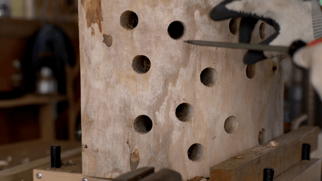 Woodcraft artisan carving a wooden hole with a chisel
