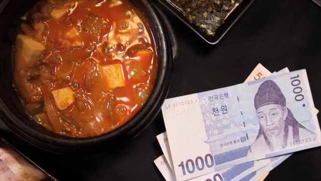 Soybean paste jjigae and currency on a table