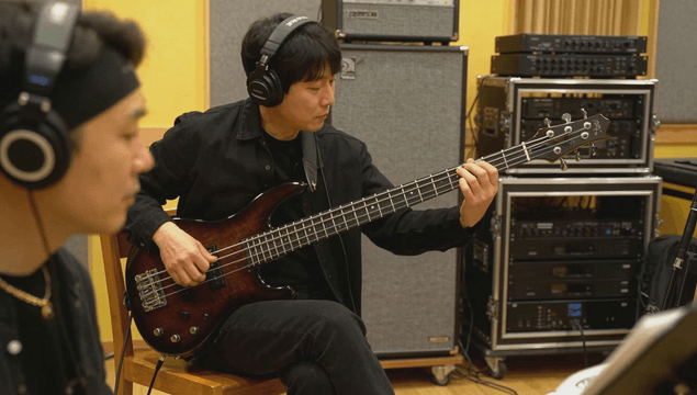 Musician playing bass guitar in studio