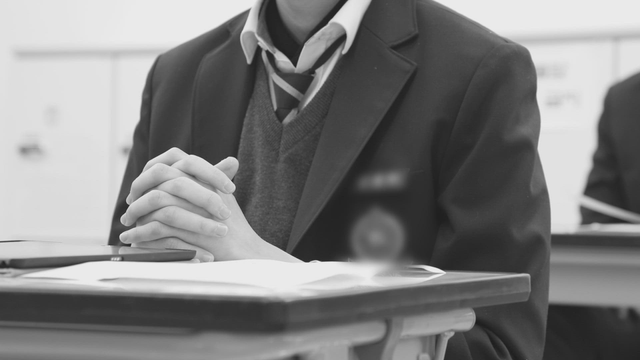 Student in uniform sitting at a desk