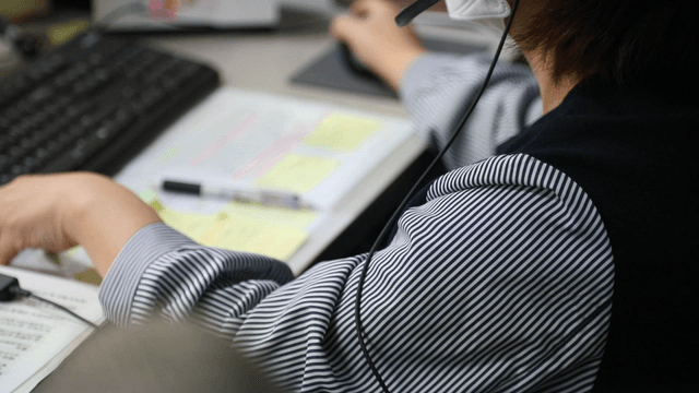 Office worker using a computer and headset