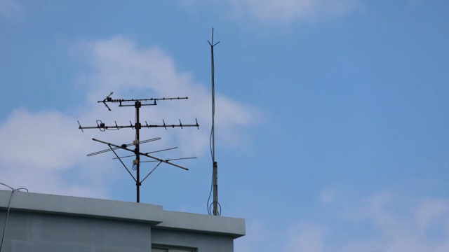 Rooftop antennas against a blue sky