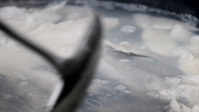 Ladle pressing cod soup