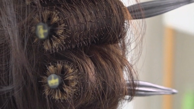 Hair being styled with a round brush