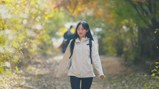 Young woman walking on autumn forest trail
