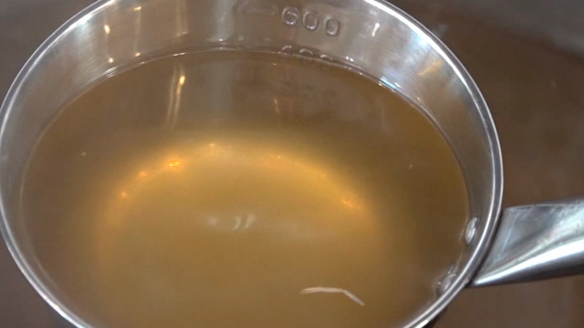 Ladle scooping broth from a pot