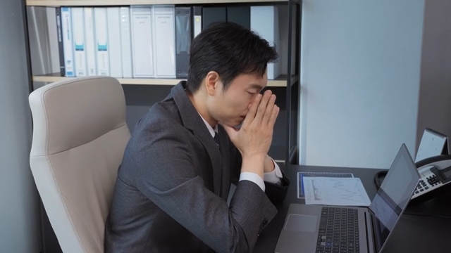 책상에서 깊은 생각에 잠긴 직장인