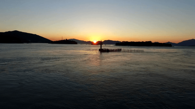 Sunset over a calm sea with distant islands