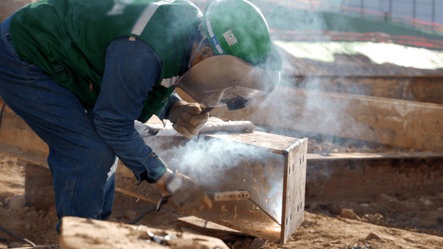 건설 현장에서 금속 빔을 용접하는 작업자