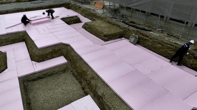Workers laying insulation at a construction site