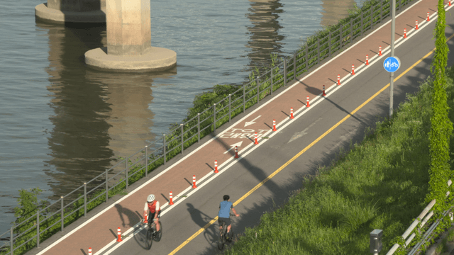 People riding bicycles along riverside path