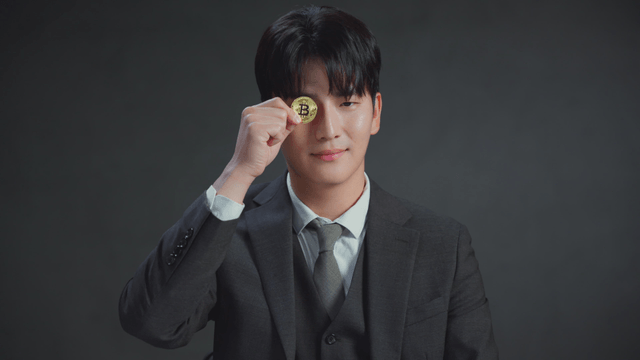 Man holding a Bitcoin coin with a smile