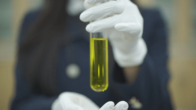 Student holding a test tube with yellow liquid