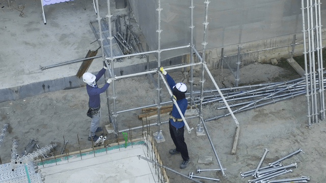 Construction workers assembling scaffolding