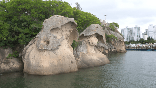 잔잔하게 흐르는 물가에 자리한 기묘한 형태의 바위